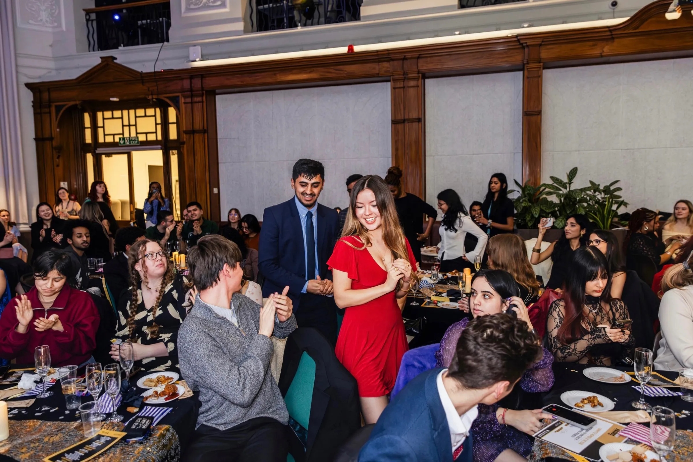 Me, in a red dress, walking up through a crowded society awards gala dinner as the tables applaud.