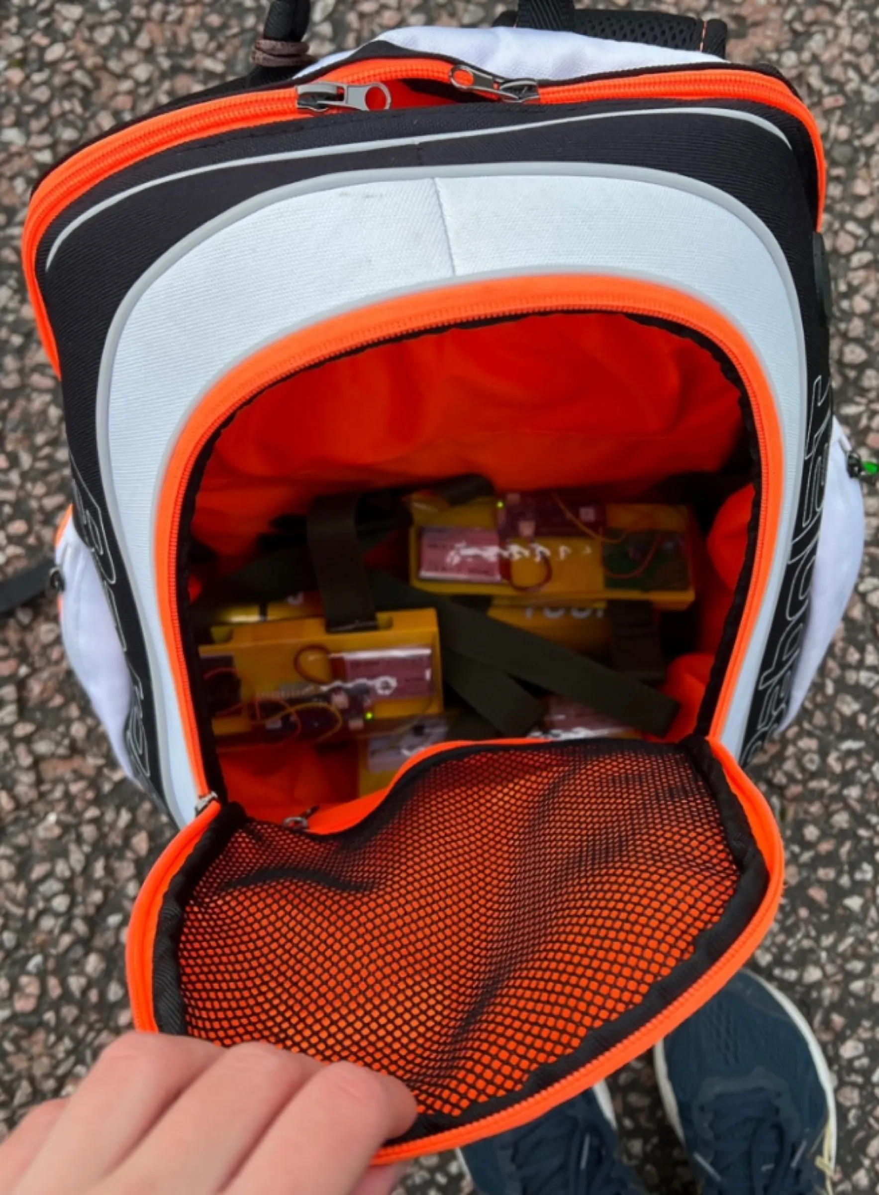 Tiles packed inside an open tennis backpack, in among the straps.